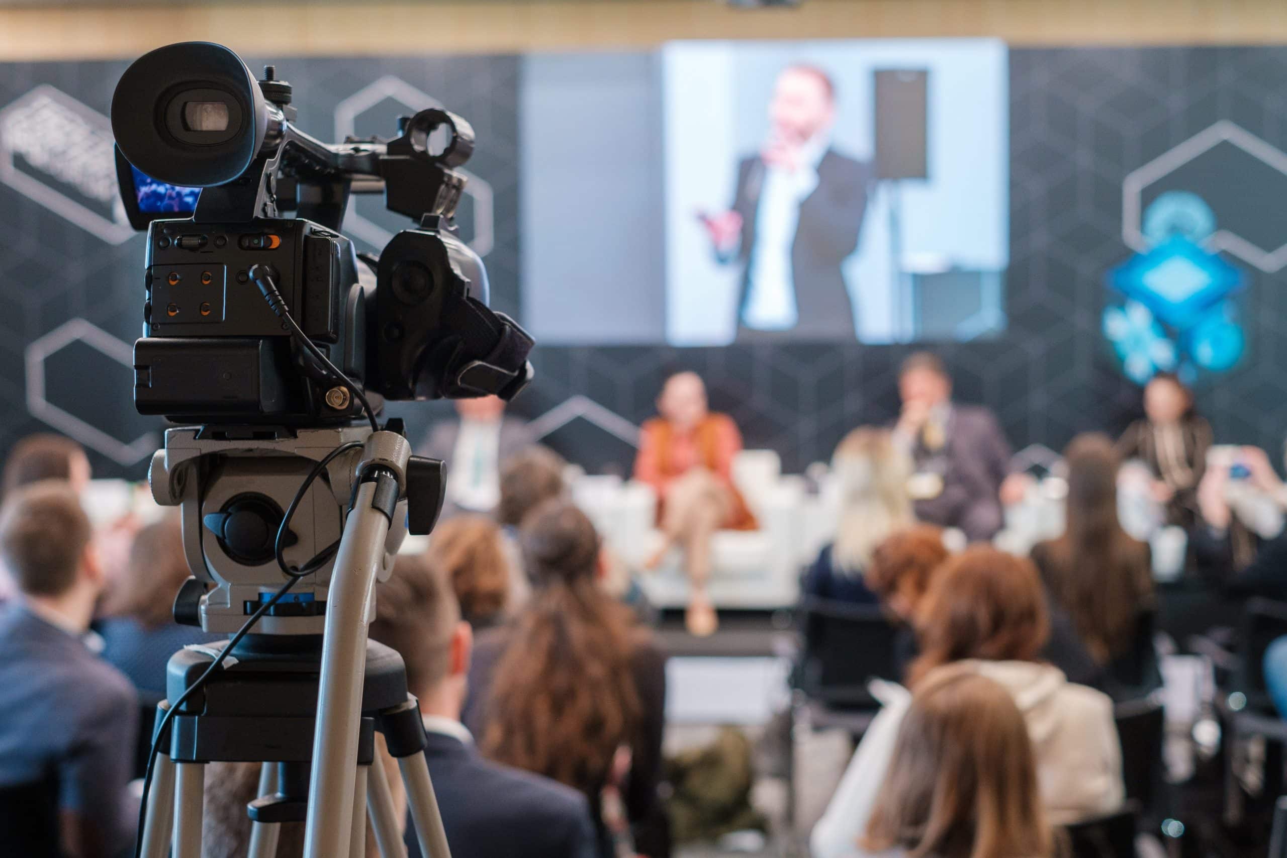 Video production in corporate auditorium recording a hybrid event.